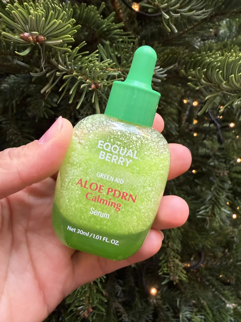 Eine Hand hält das grüne EQQUALBERRY Aloe PDRN Serum.