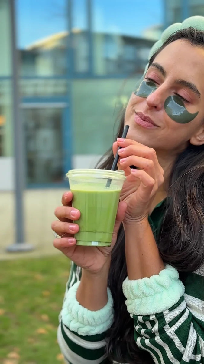 Sylvia mit Matcha-Getränk und grünen Augenpads im Freien.